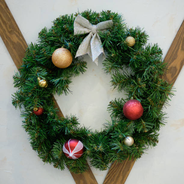 istock Christmas wreath with toys on the white wall. 1200059413