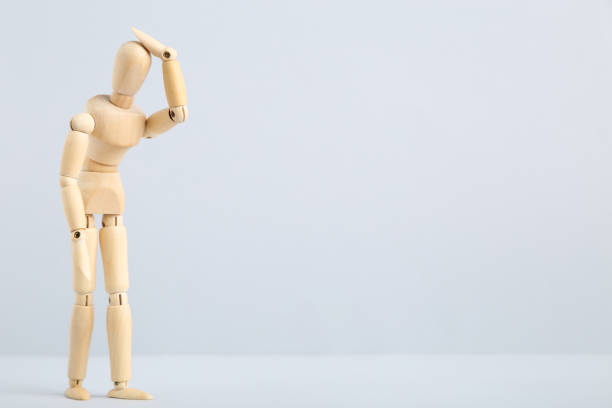 istock Wooden figure having headache on gray background 1200059433