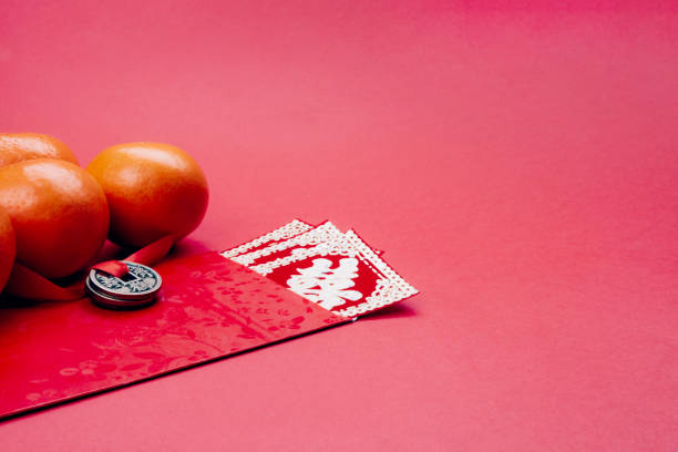 Decorations for the Chinese new year on a red background. Tangerines, envelope, wishes of love and wealth