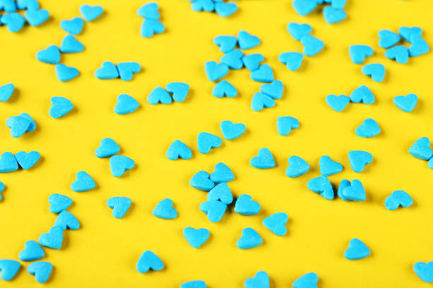 istock Heart shaped sprinkles on yellow background 1200062661