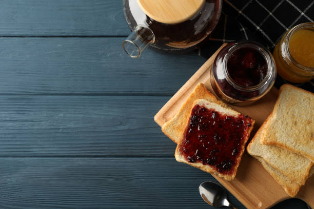 istock Toasts, jam and tea on wooden background, top view 1200068241