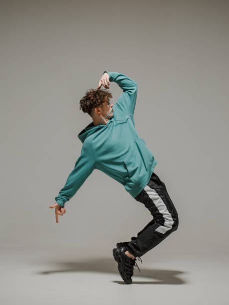 istock Guy dancing contemporary dance in studio. Neutral grey background. Acrobatic bboy dancer. 1200068581