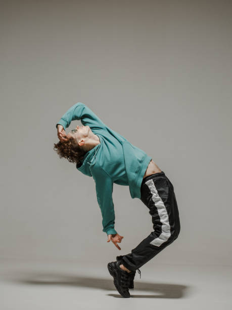 istock Guy dancing contemporary dance in studio. Neutral grey background. Acrobatic bboy dancer. 1200068697