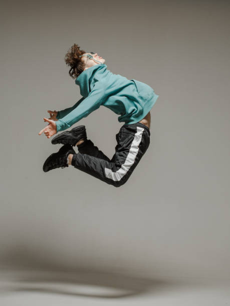 istock Guy dancing contemporary dance in studio. Neutral grey background. Acrobatic bboy dancer. 1200069443