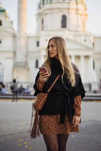 istock Attractive woman walking with cellphone in hand 1200069551