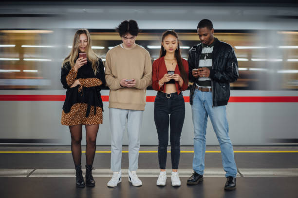 istock Multi-ethnic friends using cellphones at subway 1200069847