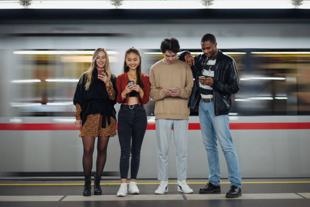 istock Multi-ethnic friends using cellphones at subway 1200070141