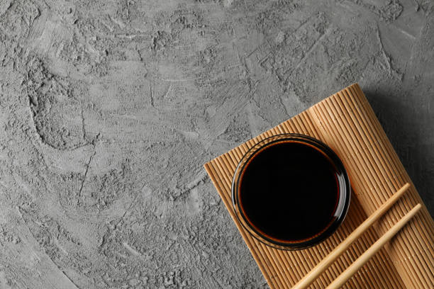 istock Bowl of soy sauce on gray background, space for text. Top view 1200071669