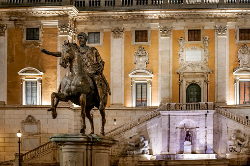 Rome, Italy -- A night view of the bronze copy of the equestrian statue of Emperor Marcus Aurelius, located in the center of Piazza del Campidoglio (Roman Capitol Hill Square) in the heart of Rome. The Palazzo del Campidoglio, in the background, is currently the seat of the municipal government of Rome. The original statue is kept inside the Capitoline Museums, a few meters away. Image in HD format