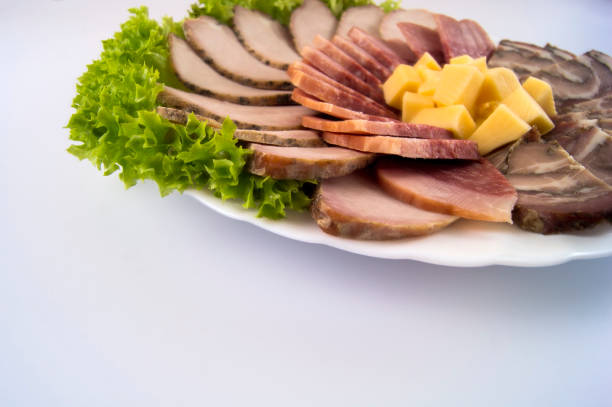 Sausage with baked meat and meat roll on a light background
