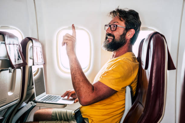 istock Bearded caucasian adult man sit down inside the airplane flight asking for hostess help -modern internet connection onboard service - people at work everywhere in digital nomad lifestyle 1200083114