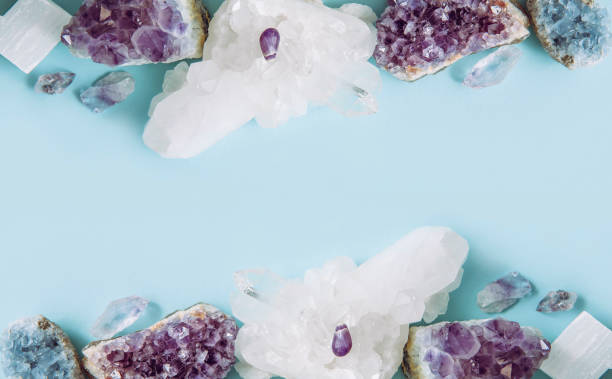 istock Frame made out of and raw natural crystal geode clusters, amethyst, celestite, quartz on light blue background for copy space. 1200085730