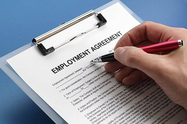 Caucasian hand filling out an employment agreement contract stock photo
