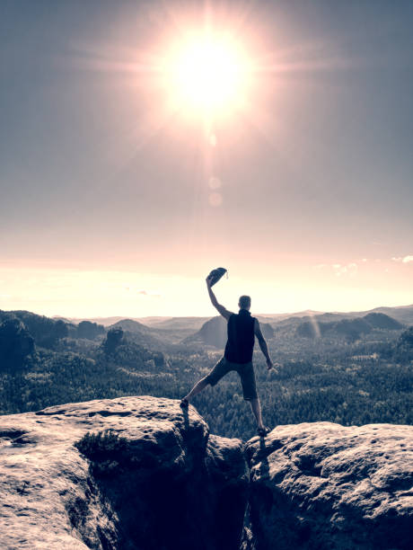 istock Man with arm outstretched celebrating sunset in mountains 1200086871