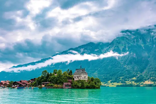 View of the peninsula and former castle and Lake Brienz in swiss village Iseltwald, Switzerland