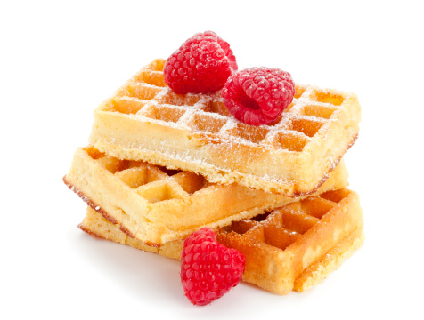 three waffles stacked, garnished with raspberries, isolated on white