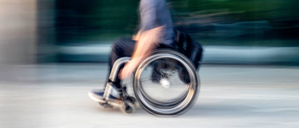 istock Man on wheelchair rolling on the street 1200091271