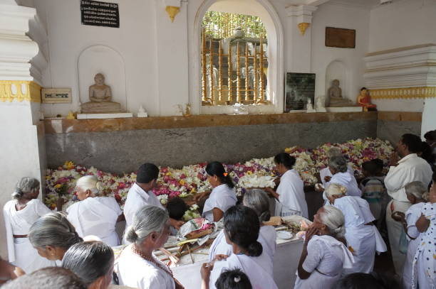 信者の地元の人々は、満月祭りの間に花の形で仏祭壇に供物を置きます。 - north central sri lanka ストックフォトと画像