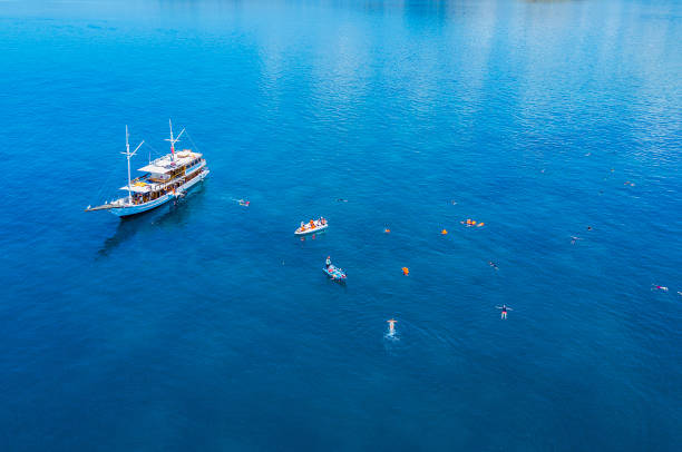 vista aérea de um yatch e de um turista que snorkeling no console das flores - labuanbajo - fotografias e filmes do acervo