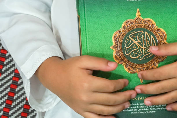 istock Boy reading al Quran during fasting month (Ramadhan ). DOF and copy space. 1200097910