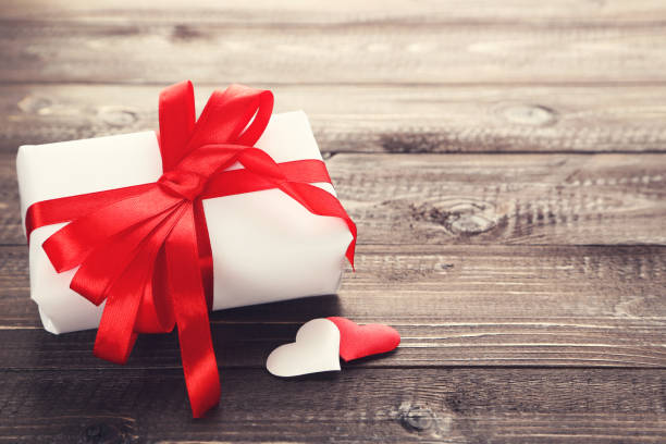 istock Gift box with ribbon and hearts on wooden table 1200097961