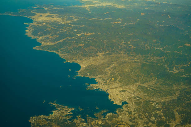 Plane soaring above a vast body of water. Scenic aerial shot of sea and land
