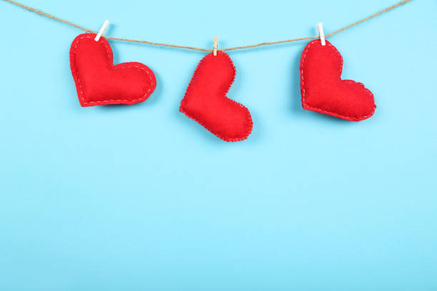 istock Fabric hearts with clothespins hanging on blue background 1200098724