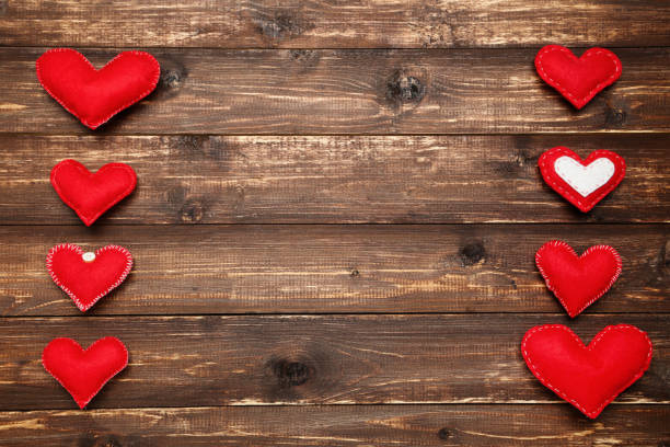 istock Red fabric hearts on brown wooden table 1200099330