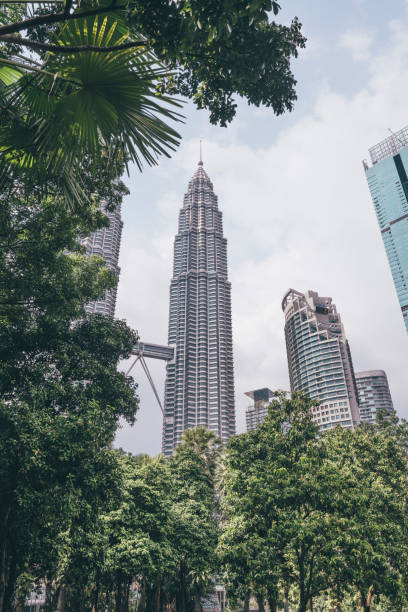 istock Kuala Lumpur skyscrapers seen through lush green trees 1200103245