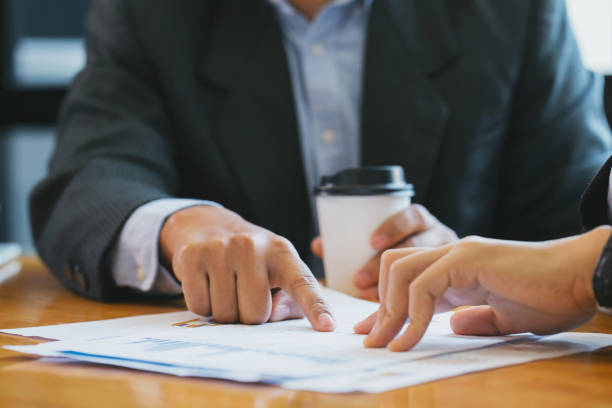 istock Close-up of Businessman hands pointing at business document while discussing it 1200105034