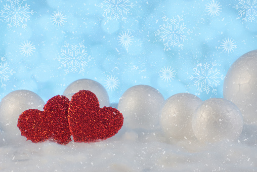 Two hearts together on a beautiful snow winter background. Love and St. Valentines Day concept