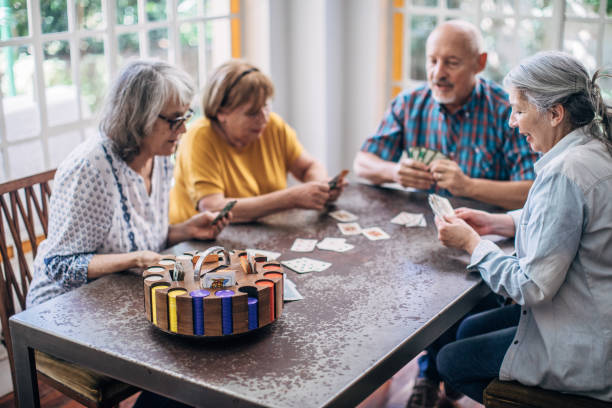 istock Old friends having fun playing cards 1200108142