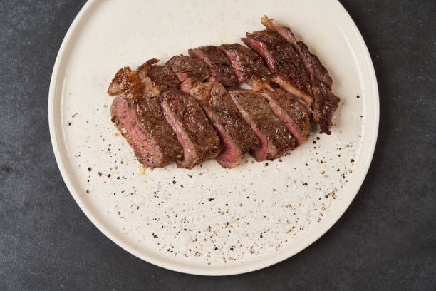 istock Grilled beef steak with spices on a white tray, close-up 1200111938