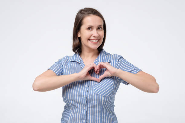 istock Mature hispanic woman making a heart shape with her hands 1200112491