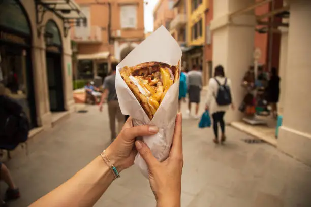 Female hands holding one big Gyro sandwich. This sandwich is part of Greek traditional cuisine. Photo made in Corfu