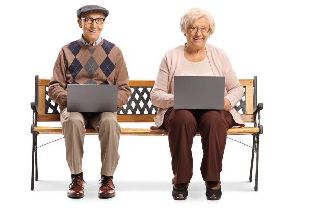 istock Grandmother and grandfather sitting on a bench and using laptop computers 1200116075