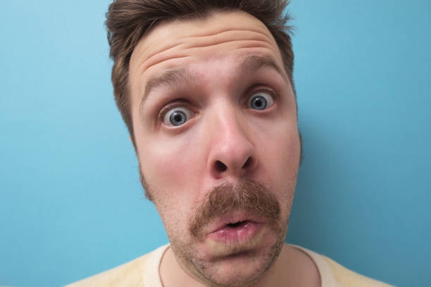 istock Amazed young man portrait isolated on blue background 1200116114