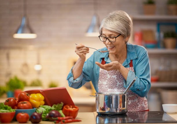 a mulher está preparando vegetais - mãe dona de casa - fotografias e filmes do acervo