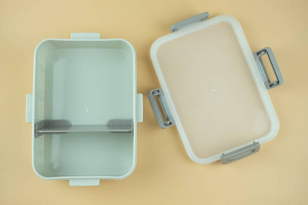 Open plastic lunch box with lid on yellow background. Concept of reduce use plastic Open plastic lunch box with lid on yellow background. Concept of reduce use plastic empty bento box stock pictures, royalty-free photos & images