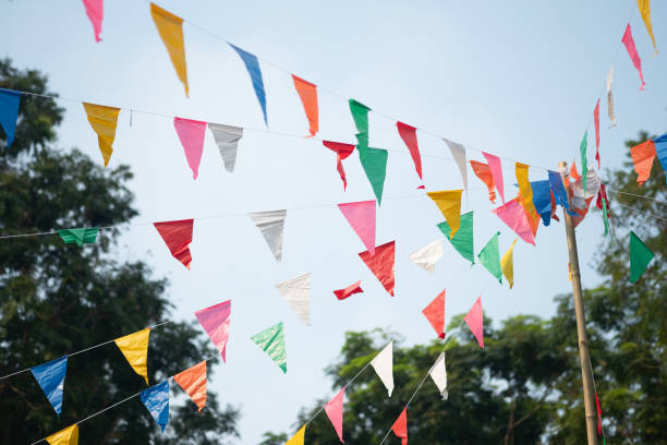 kolorowe trójkątne flagi z niebieskim niebem w tajskim czasie zabawy festiwalowej - otwarta przestrzeń ustawienia zdjęcia i obrazy z banku zdjęć