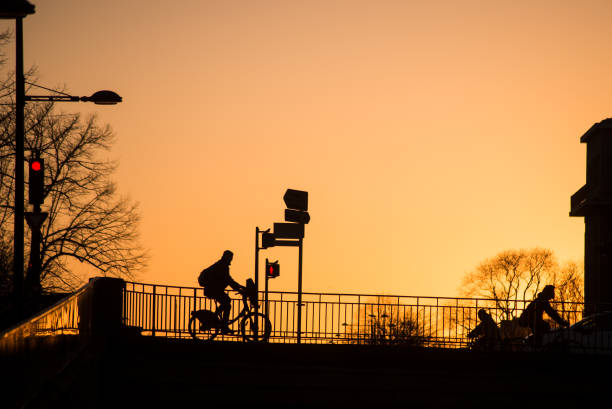 silhouette von bikern, die auf brückensilhouette bei sonnenuntergang vorbeifahren - mühlhausen stock-fotos und bilder