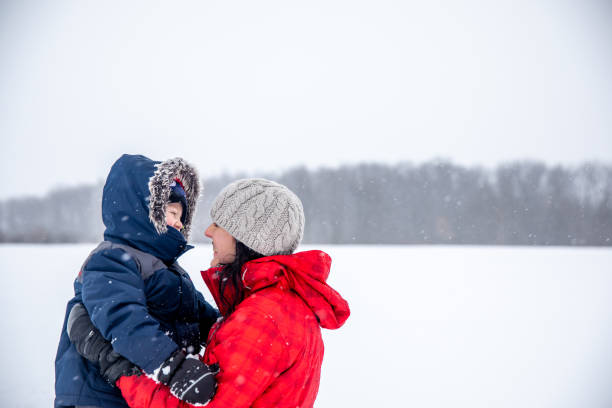 istock Mother and Son Having Fun Outdoors During Snowstorm 1200121327