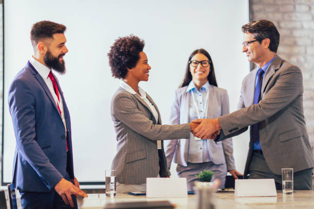 Diverse business partners shaking hands starting collaboration at group negotiations Business people shaking hands in the office. Finishing successful meeting. coalition photos stock pictures, royalty-free photos & images