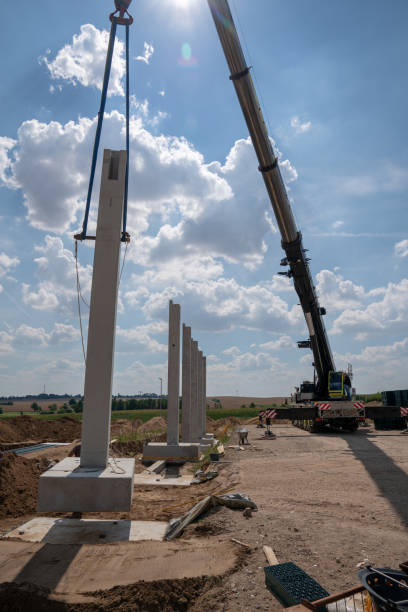 istock on a construction site, concrete columns for a factory building are placed with the help of a large crane 1200123501