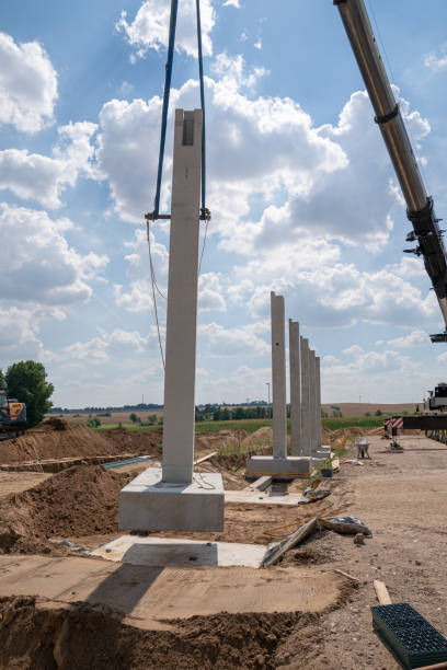istock on a construction site, concrete columns for a factory building are placed with the help of a large crane 1200123519