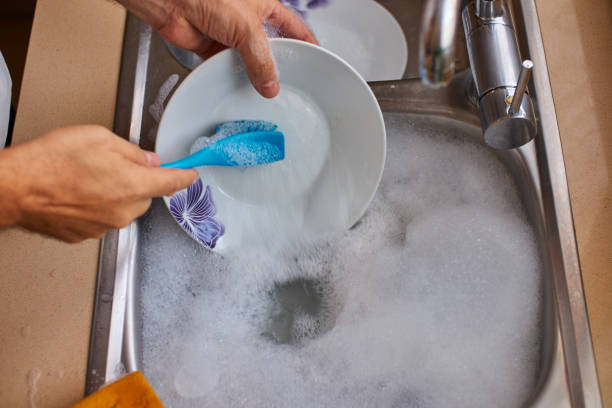 scrubbing the dishes in the kitchen - sink domestic kitchen kitchen sink faucet imagens e fotografias de stock