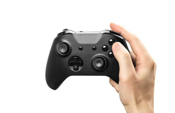 istock The hand holds a black gamepad for playing computer games. Isolated on a white background. Close up 1200124959