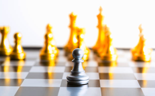 istock One gold pawn chess piece is standing alone on chessboard. 1200125553