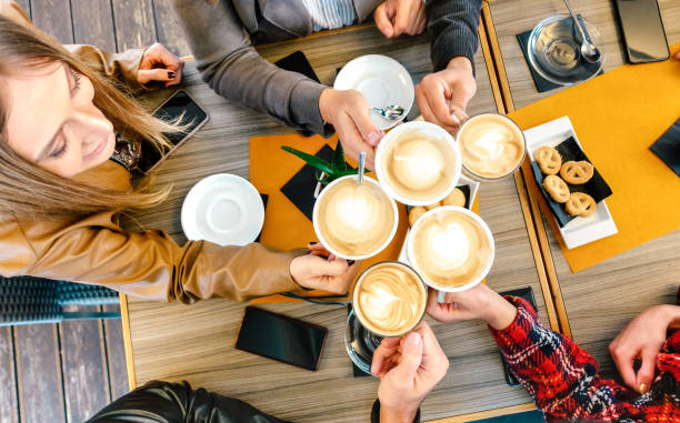 top view of friends toasting cappuccino at coffee shop restauran - breakfast eating people teens imagens e fotografias de stock