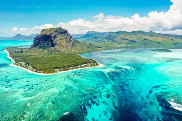 Aerial panoramic view of Mauritius island - Detail of Le Morne Brabant mountain with underwater waterfall perspective optic illusion - Wanderlust and travel concept with nature wonders on vivid filter